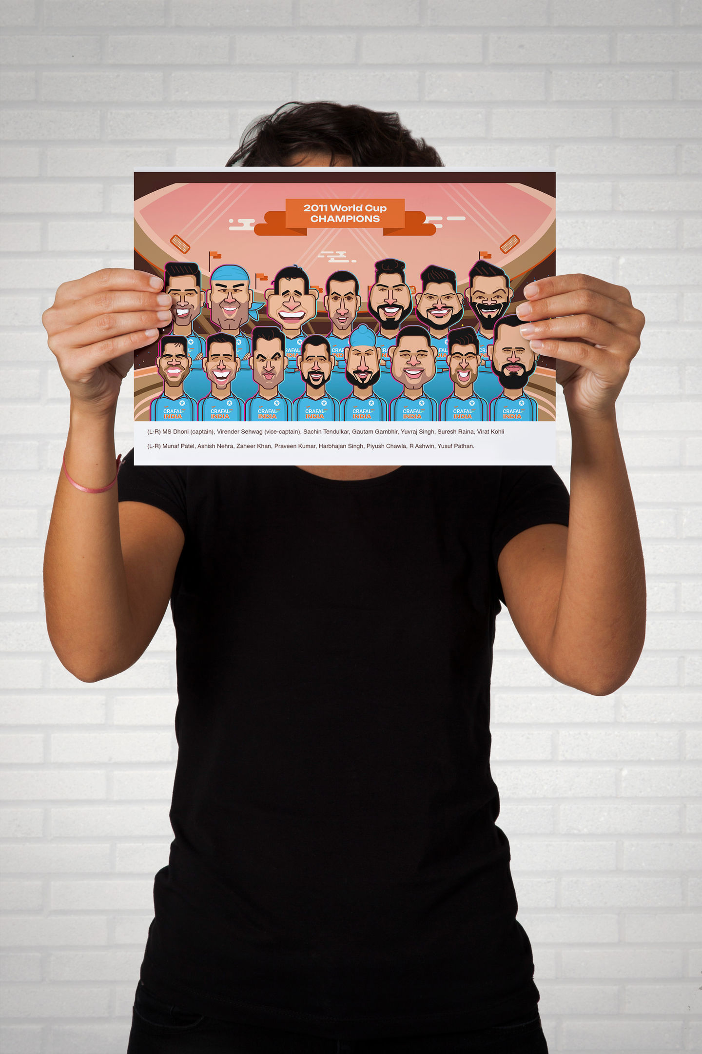 Person holding a cartoon print of the 2011 World Cup Champions- Indian Cricket Team