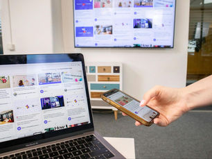 A person checking a website on three different screen sizes.