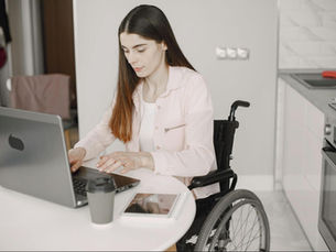 A woman in a wheelchair browsing the website of an NDIS provider.