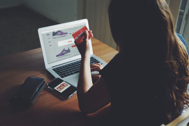 Person shopping online with a laptop and credit card.