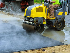 Asphalting construction works with commercial repair equipment road crews.jpg