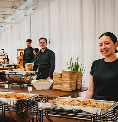Staff members ready to serve a buffet for party guests