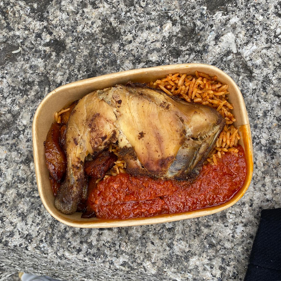 jollof rice and chicken leg in a paper container