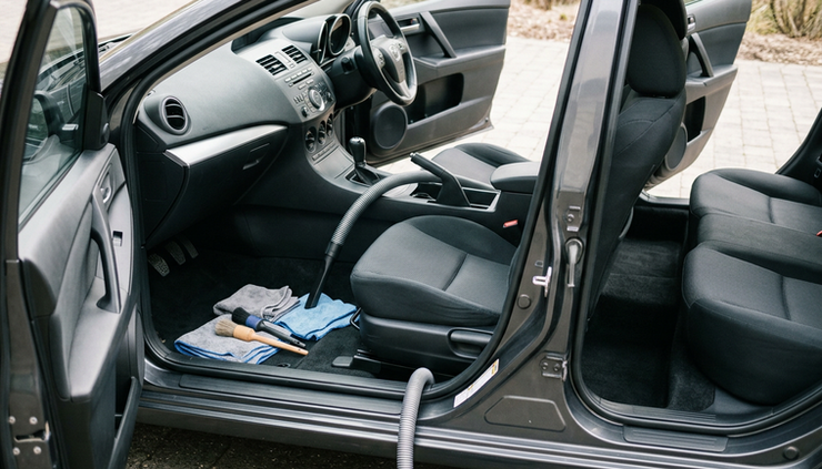 Eye-level view of car interior being cleaned with tools arranged nearby