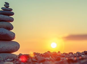 Pyramid of stones on the beach at sunset, beautiful seascape, rest and seaside vacation co