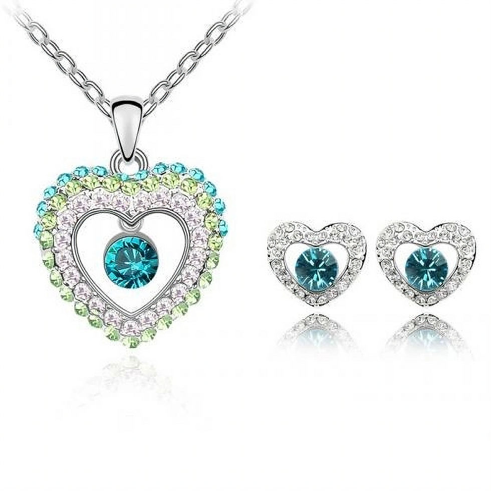 Weißvergoldetes Herz-Schmuckset mit blauen und grünen Kristallen, umrahmt von klaren Steinen.