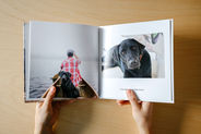 Person holding a SimplePrints photo book of their pet dog