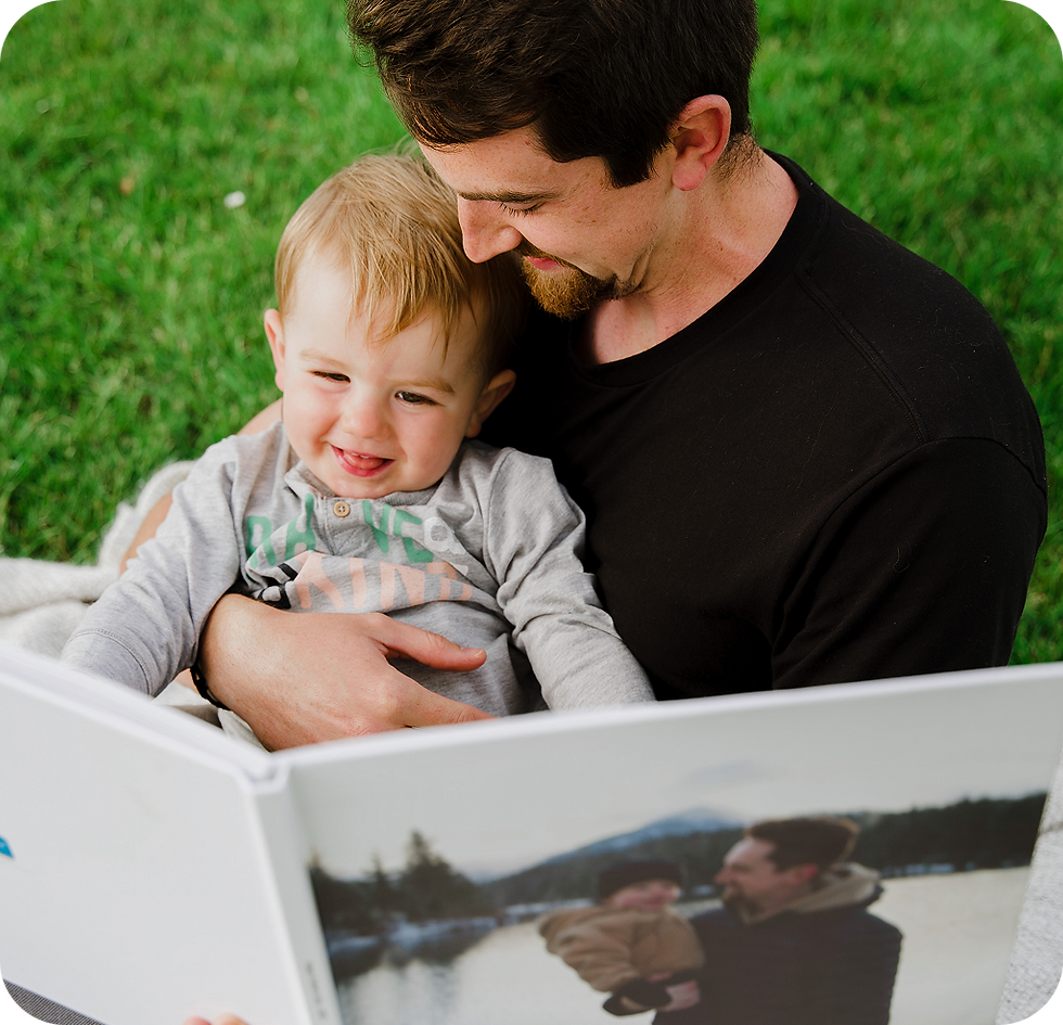 Happy Dad and kid looking at SimplePrints photobook.png