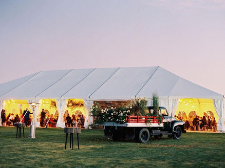 At alpen glow lighting an illuminated wedding tent filled with love and a 1950 Chevy grain truck filled with flowers highlight Colorado ranch wedding venues.