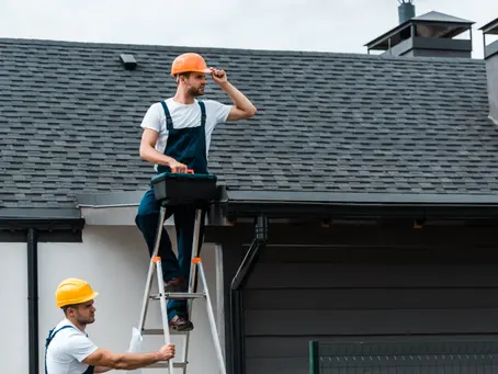 repairman sitting on roof and holding