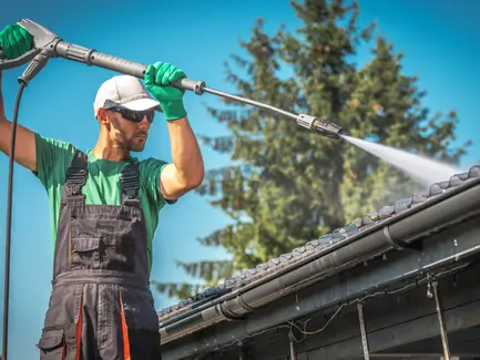 man in uniform clean the roof with soft wash hose