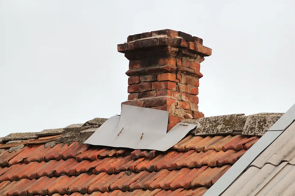 old red brick chimney on tiled roof
