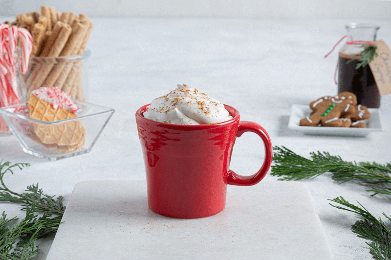 Gingerbreas Latte with a gingerbread man being dunked in.