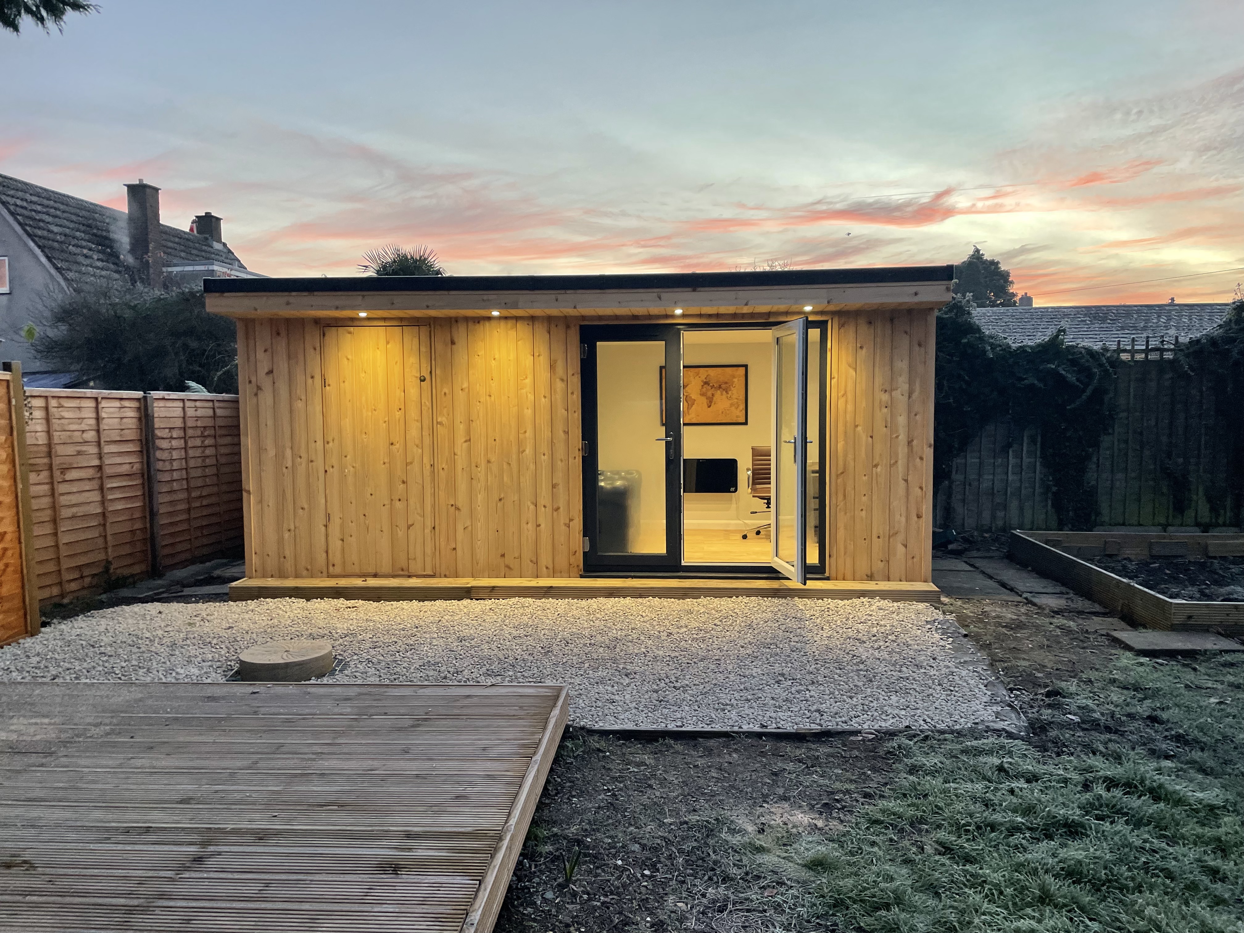 The Balmoral Garden Room with lit spotlights in a home backyard seen here at dusk.