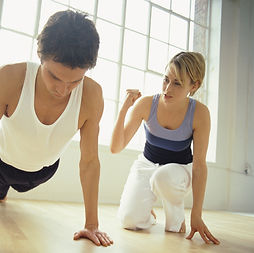 Personal trainer begeleidt klant bij training thuis