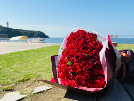 青空と江の島を背景にした赤い薔薇の花束