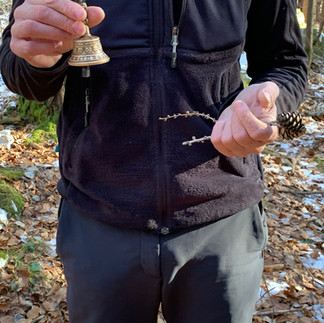 Mano suona una campanella in bosco