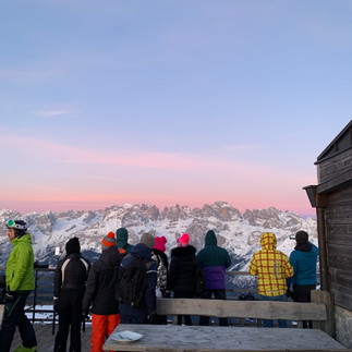 gruppo di gente che ammira l'alba in montagna