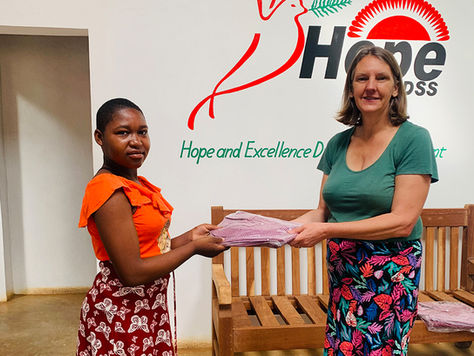 Hope4Malawi trustee Sara Goodman presenting a student with her school uniform