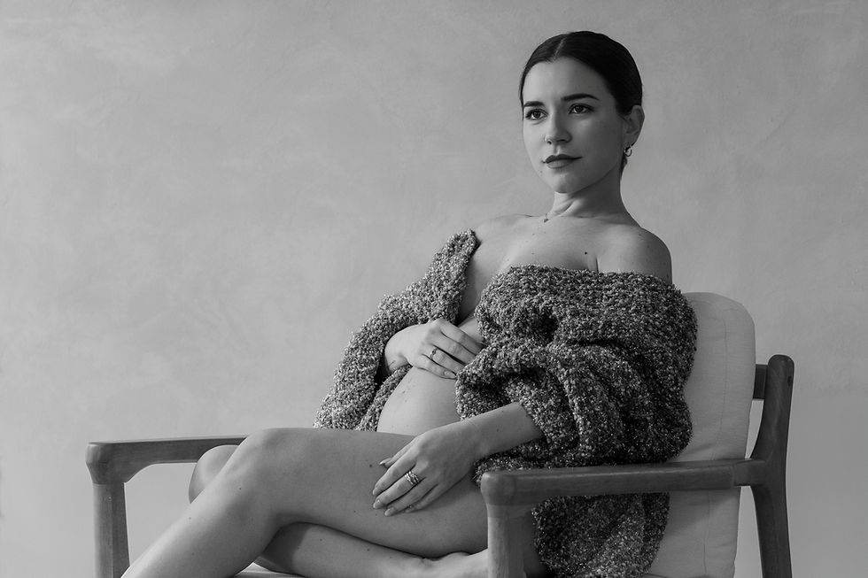 Retrato en estudio de mujer embarazada en blanco y negro con expresión serena