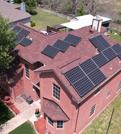 Technician washing rooftop solar panels in Forney, Texas