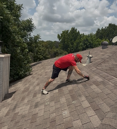 Roofer inspecting asphalt shingle roof in Forney, Texas