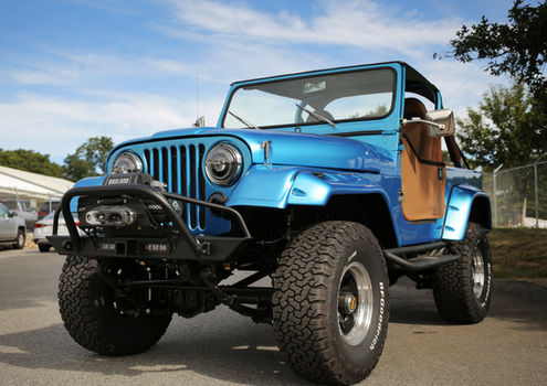 Front three-quarter view of the blue Jeep CJ7 on off-road tires at Angels Touch Restoration.