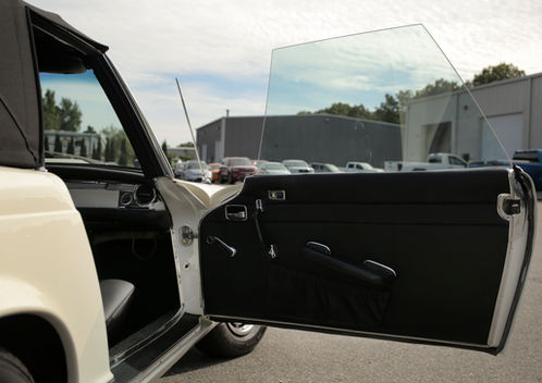 Open passenger door with black door panel on the cream Mercedes-Benz 280SL at Angels Touch Restoration.