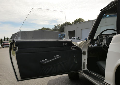Open driver door with black door panel on the cream Mercedes-Benz 280SL at Angels Touch Restoration.