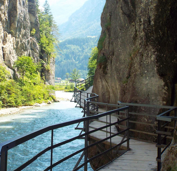 Walkway through the narrow Aare Gorge, clinging to rock walls above the turquoise Aare River.