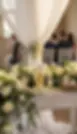 Gepersonaliseerde kaars tussen witte rozen bij ceremonie