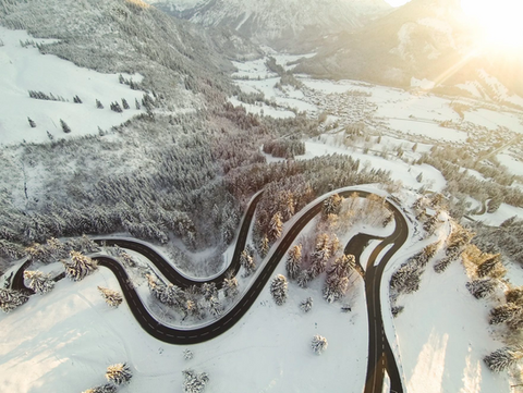Winter aerial of the Rossfeld Panoramastraße, Germany’s highest panoramic mountain road in Bavaria, with sweeping snow-covered hairpin bends.