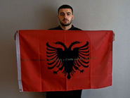 Rrezag Street artist and painter.
Rrezag and his flag with the klaus Guingand sentence in Albanian.
Flag: 23 x 35,4 in. / Sentence gold marker / Signed.