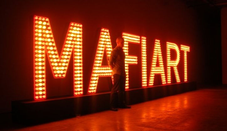 Mafiart is a work created by Klaus Guingand in 2009. Wood,metal & 852 Red & yellow flashing light bulbs 314 x 12 x 86,6 in. Mafiart TM © Klaus Guingand