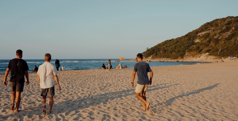 men walking on the beach at dusk