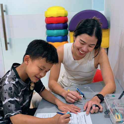 Occupational therapist working on handwriting with a child
