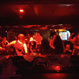 People dancing at a Dance Space daytime sober rave in Dublin with colourful club lighting.