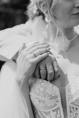 Detailfotos der Hände und Eheringe eines Brautpaares