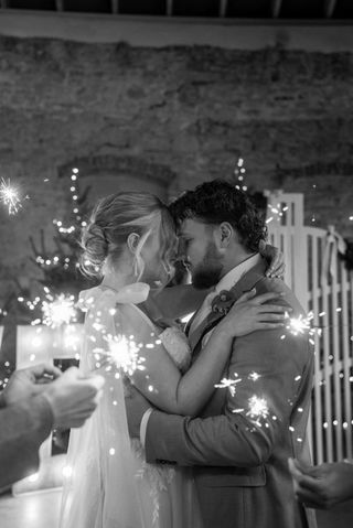 Brautpaar steht im Lichtermeer voller Wunderkerzen und genießt den Augenblick