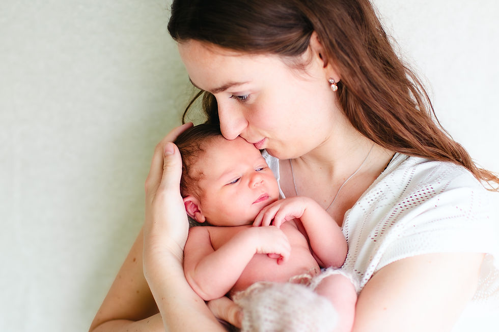 Liefdevolle moeder houdt haar newborn baby vast tijdens een professionele newborn fotosessie