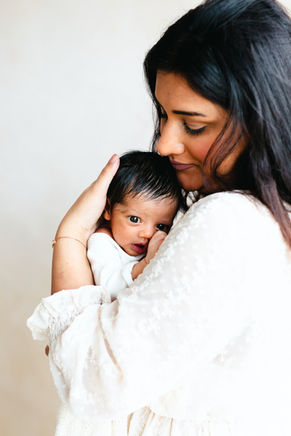 Moeder houdt haar pasgeboren baby dicht tegen zich aan
