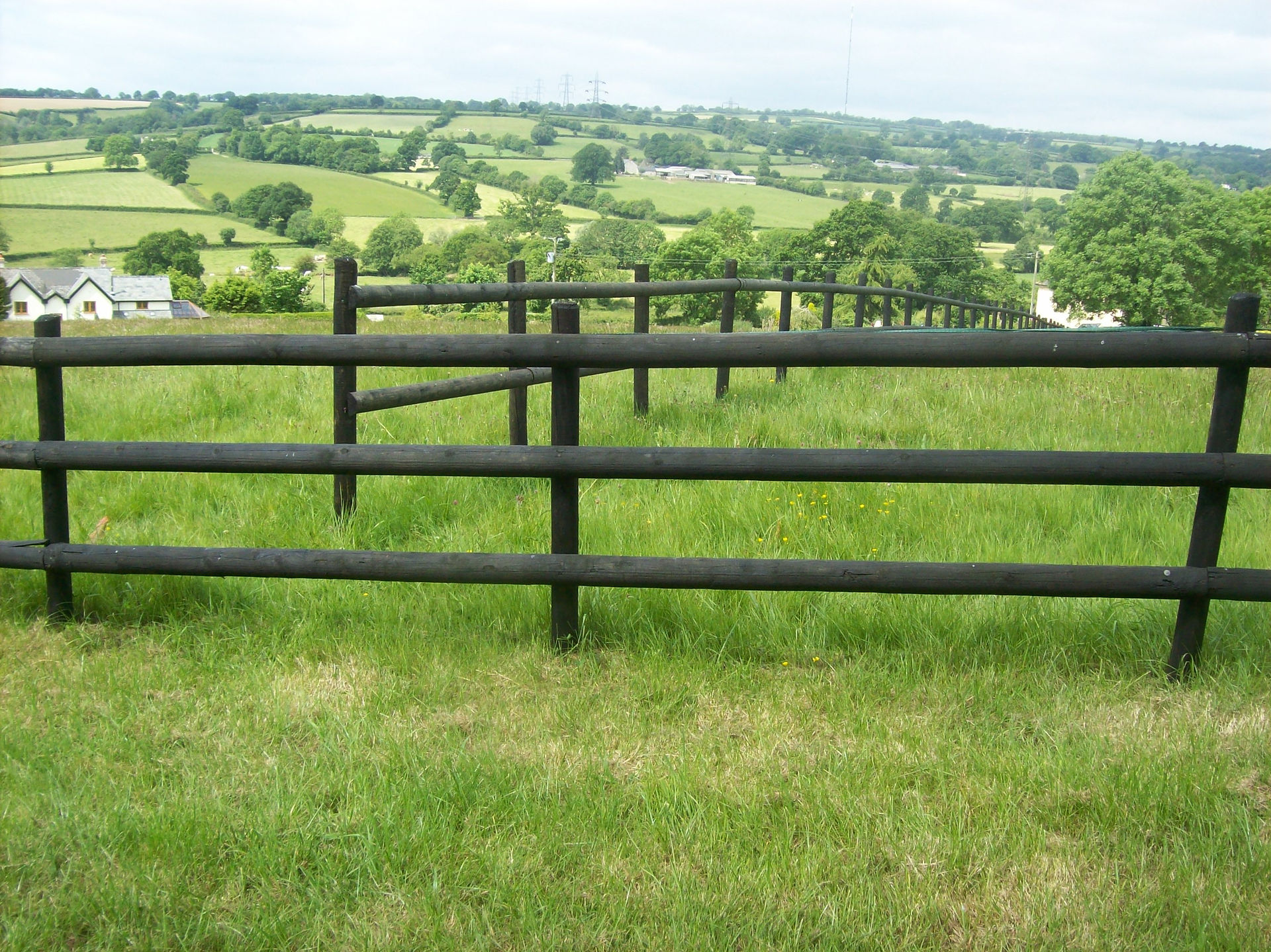 Dark brown timber fence surrounding a field