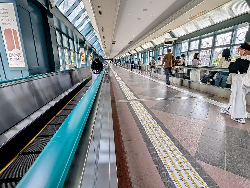 In Tokyo, a moving walkway takes tourists and commuters to their destinations in a clean, modern corridor.