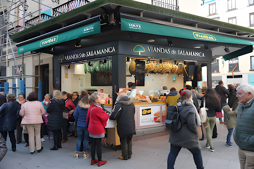 In central Madrid, crowd queue for ham and snacks at a Viandas de Salamanca street kiosk