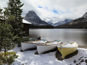 Glacier Park's beauty from lake shore with canoes