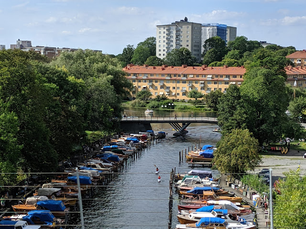 Stockholm view from the canal with boats, apartments and lush landscape