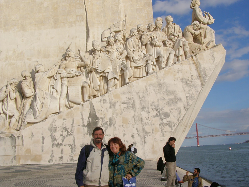 Travel bloggers Cookie and Keller pose at Discoveries Monument on Lisbon waterfront