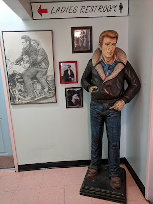 Actor James Dean leads the way to the colorful restroom. Behind the Dean manikin are photos of him with Marilyn Monroe, and other classic Hollywood portraits.