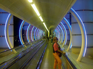 Christene ''Cookie" Meyers rides a moving walkway through a glowing blue-ring tunnel in Paris, on her way to the Folies Bergere