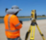Surveyor using total station equipment for topographic site measurement